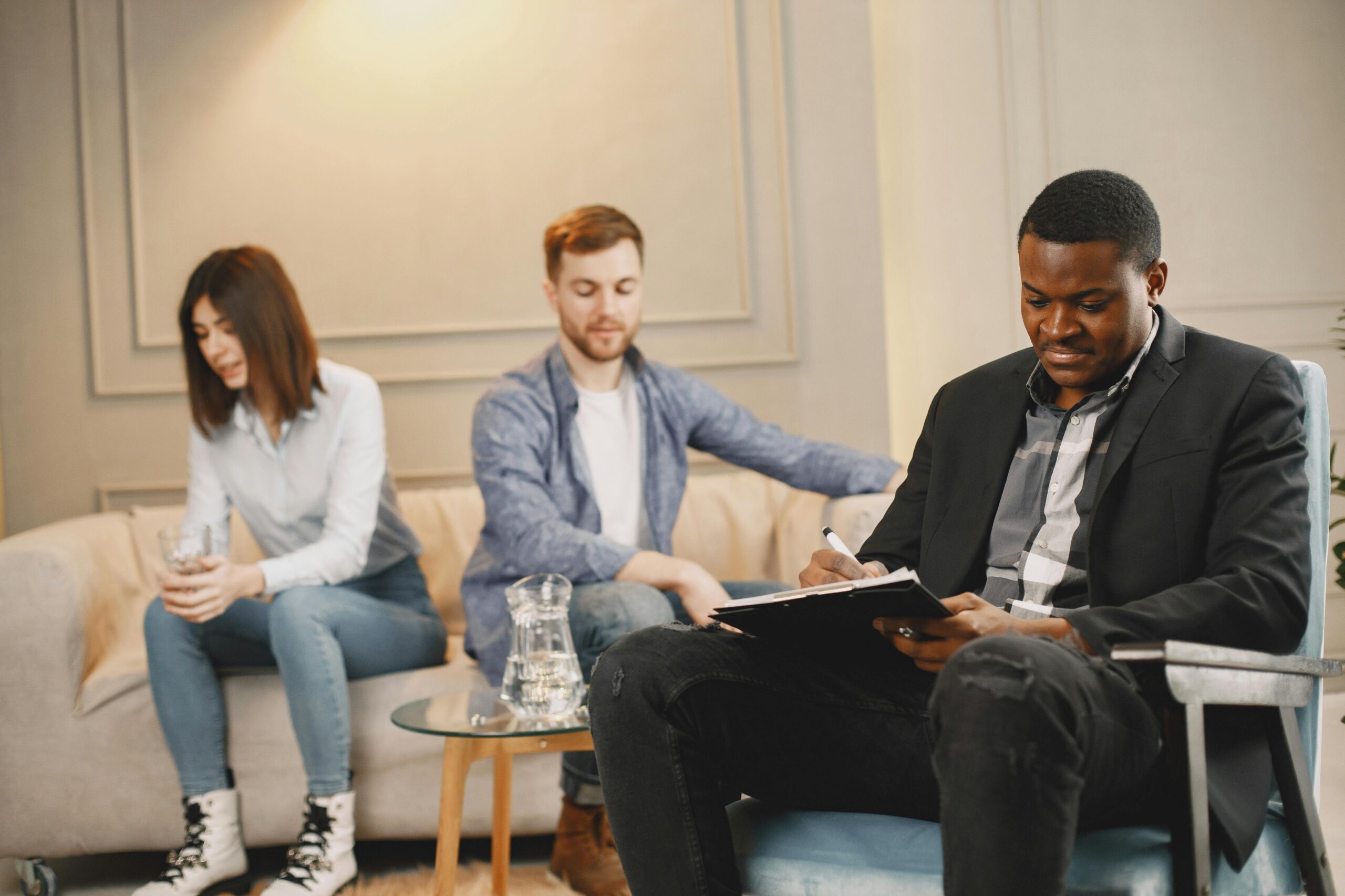 A couple discussing issues with a therapist during a counseling session indoors.